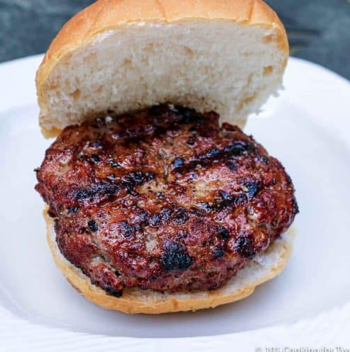 Burger with bun to the side facing upwards and with just a patty and another bun below